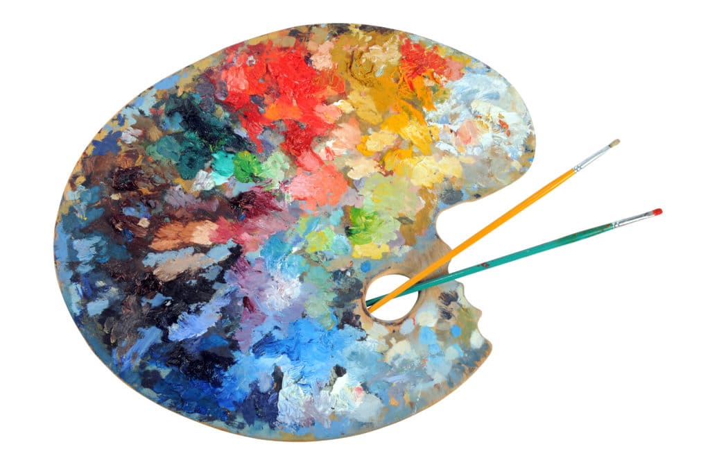 Artist's palette with paintbrushes isolated over white background - With clipping path